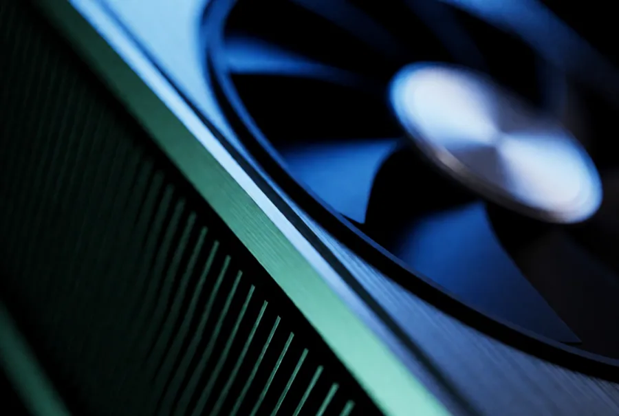 Extreme macro of a GeForce RTX graphics card heatsink lit in teal and blue