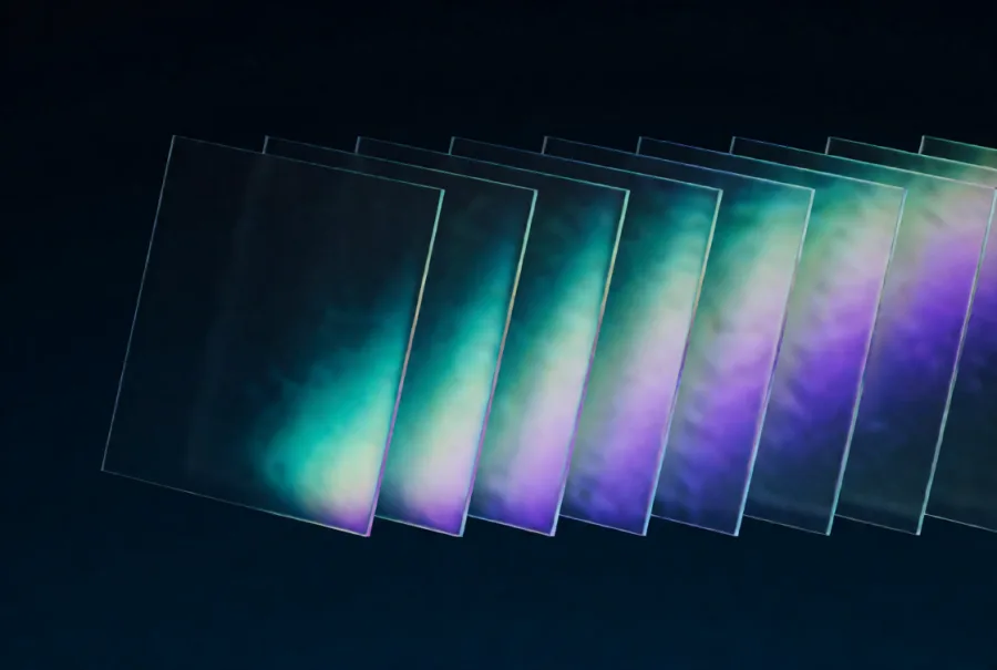 A fanned row of glass panels receding into the dark, each holding a wash of teal and violet