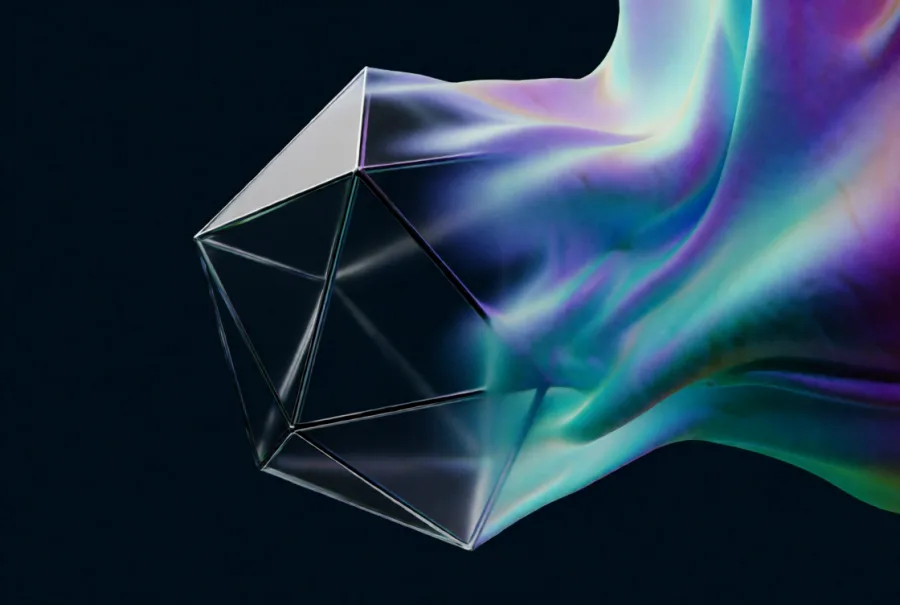 A faceted glass polyhedron with a ribbon of iridescent colour pouring out of it into the dark